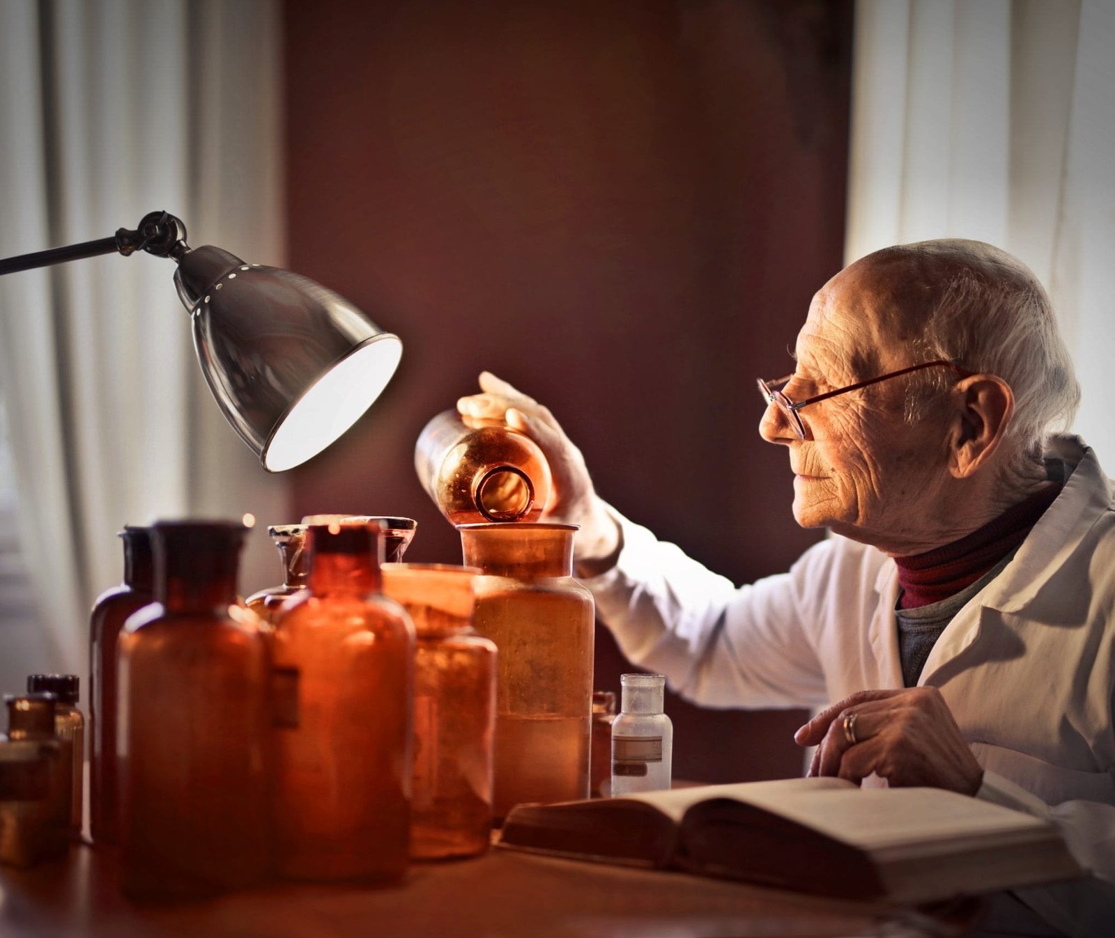 portrait of elderly man pouring a liquid into a jar